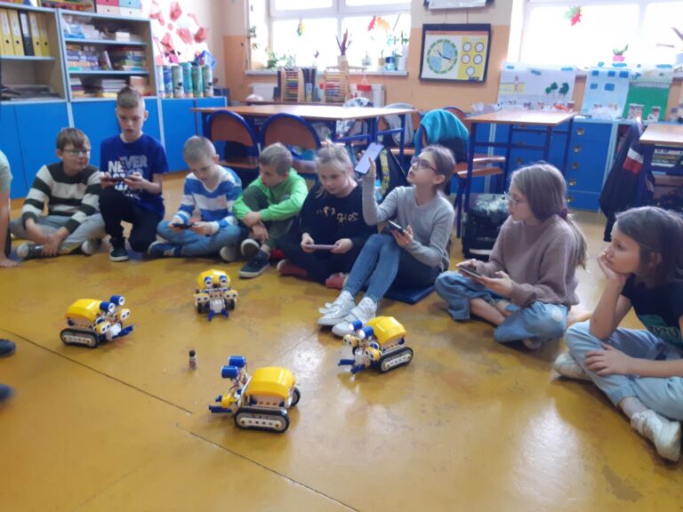 Grupa uczniów zapoznaje się z działaniem robotów.