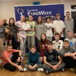 Grupa uczniów z wolontariuszami na tle planszy Euroweek