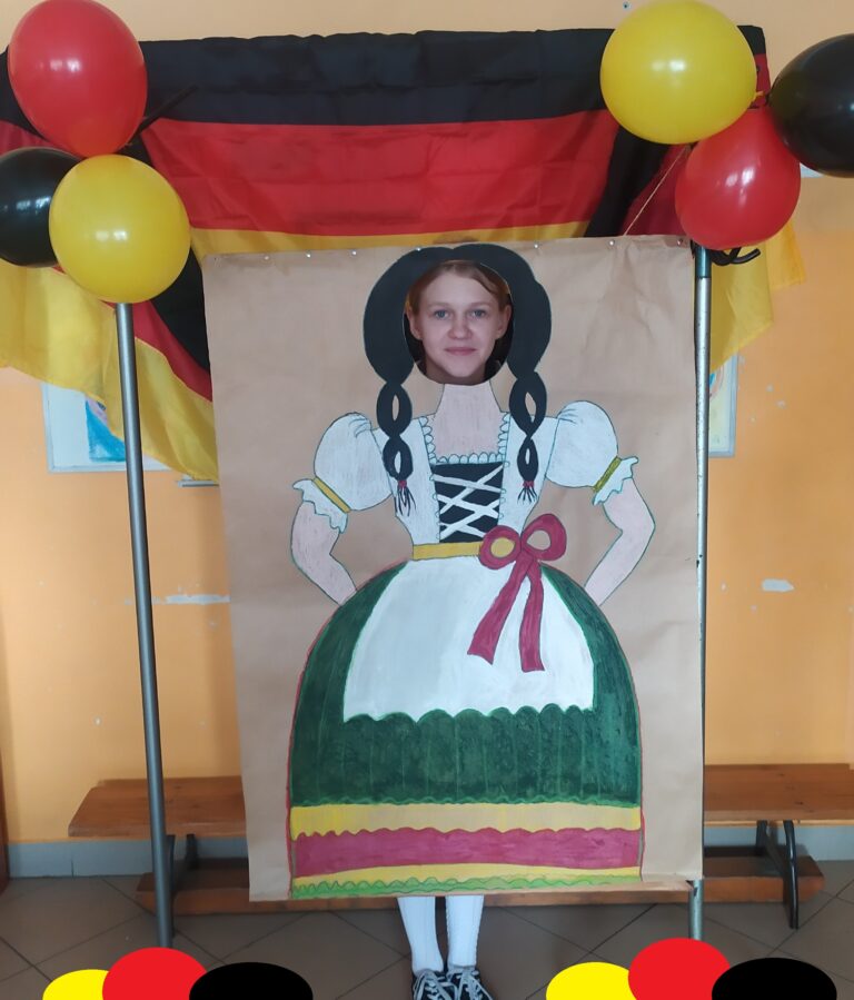 Pamiątkowe zdjęcia uczniów na foto- ściańce, która prezentuje bawarski strój ludowy charakterystyczny dla kobiet.