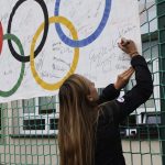Katarzyna Woźniak-Niedźwiedzka składa podpis na fladze olimpijskiej.