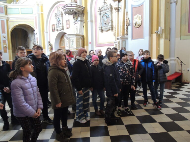 Uczestnicy wycieczki słuchają opowieści o tajemnicach zabytkowego klasztoru ojców paulinów w Oporowie.