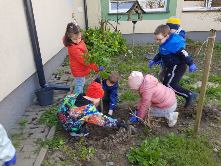 Uczniowie kl. I a sadzą drzewko.