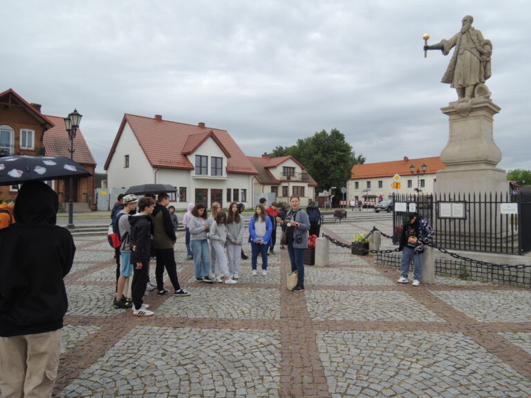 Uczestnicy wycieczki przy pomniku Stefana Czarnieckiego słuchają historii Tykocina.