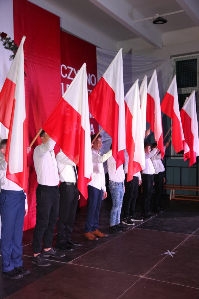 W czasie hymnu grupa uczniów tworzyła dekorację z flag