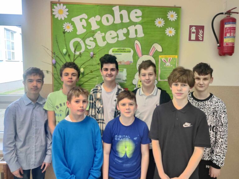 Uczniowie klasy VII na tle gazetki wielkanocnej w języku niemieckim. 