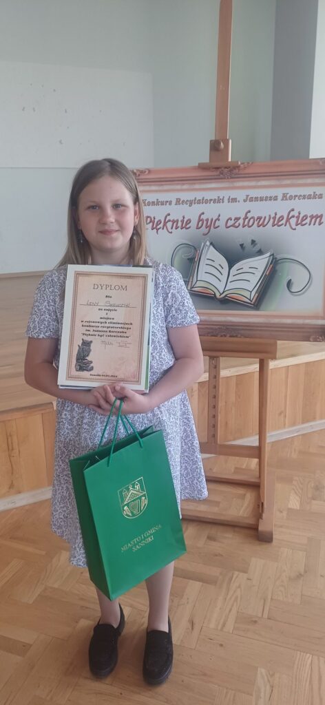 Dziewczynka prezentuje dyplom i nagrodę