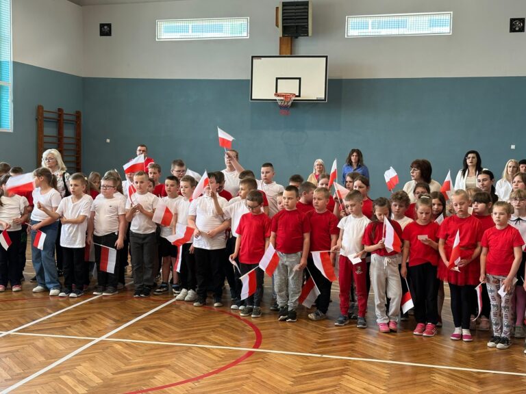 Uczniowie klas I-III w biało - czerwonych strojach.