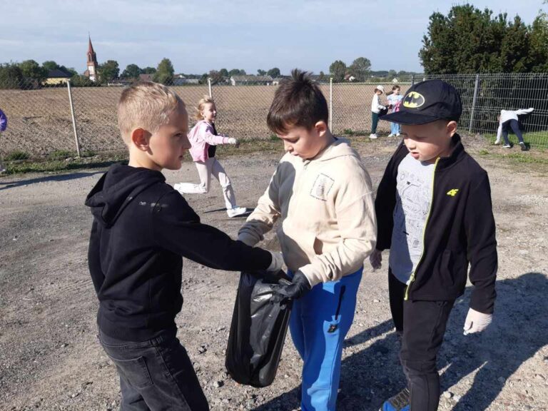 Sprzątnie terenu przy szkole przez uczniów klasy II