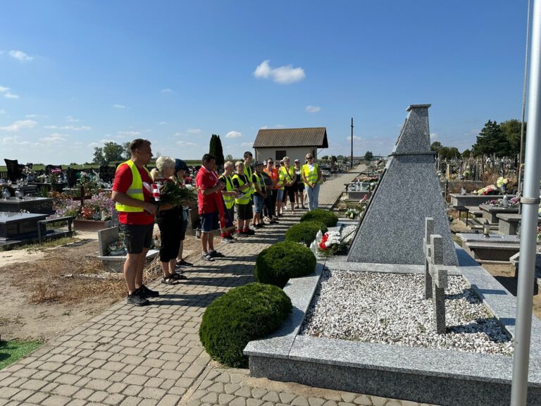 Modlitwa przy mogile żołnierzy poległych spoczywających na cmentarzu w Pacynie.