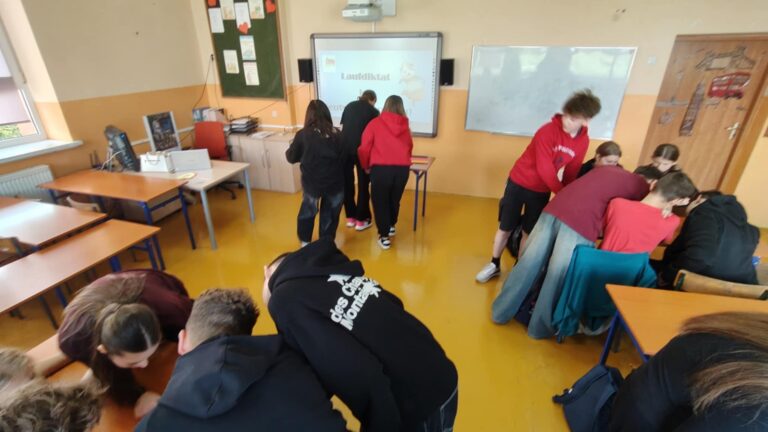 Uczniowie klasy VIII podczas zajęć języka niemieckiego - „Laufdiktat czyli biegane dyktando”.