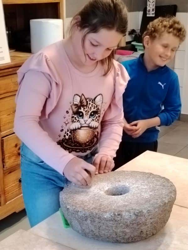 Uczniowie kl. II podczas mielenia mąki