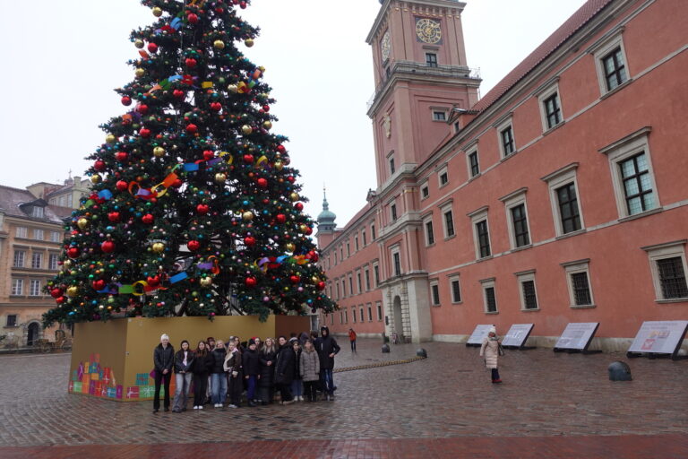 Pamiątkowa fotografia przy choince na placu przed Zamkiem Królewskim.