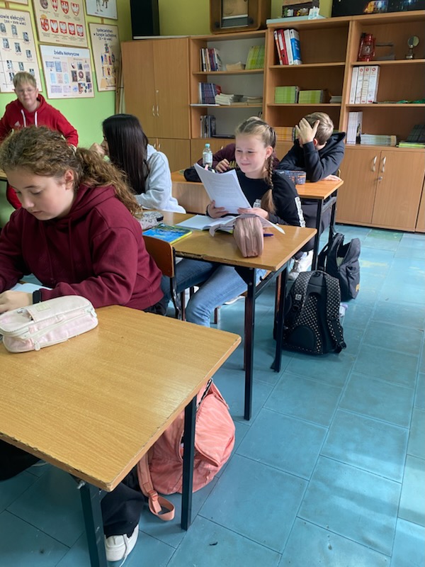 Uczennica czyta swoim kolegom