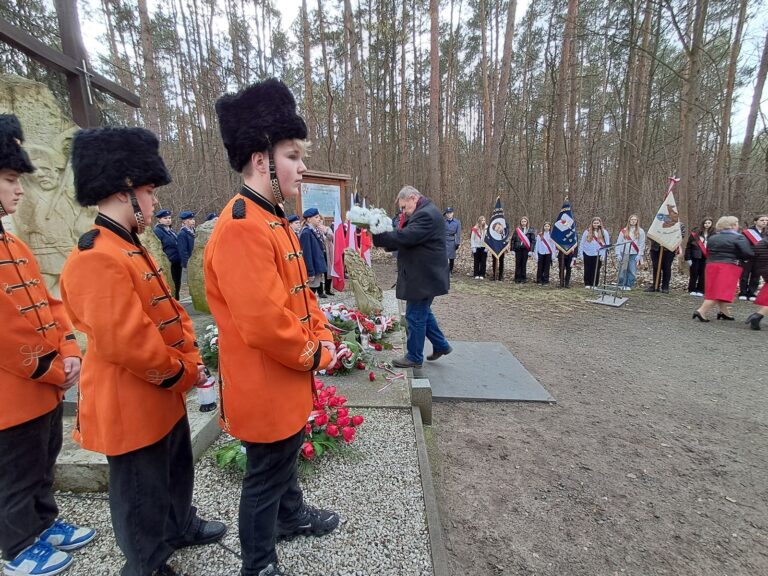 Składanie kwiatów przy pomniku.