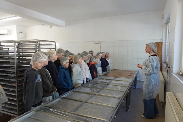 Uczniowie obserwują proces produkcji krówek.