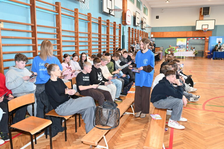 Przedstawiciele szkół średnich rozdają ulotki informacyjne