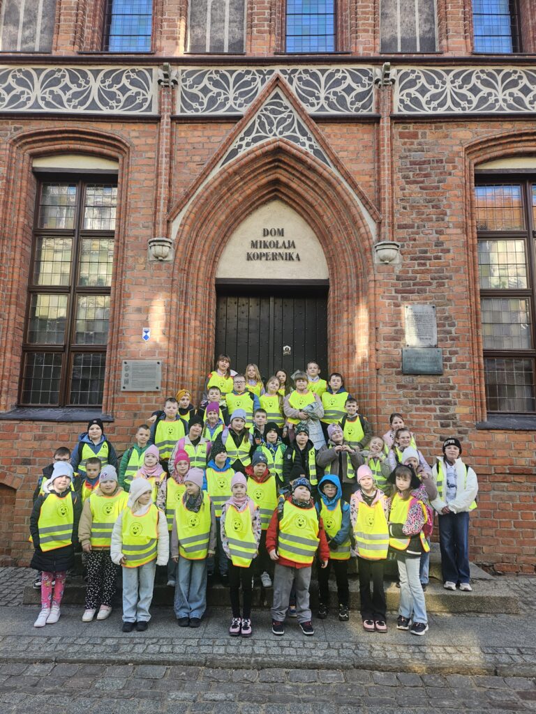Uczestnicy wycieczki przed Domem Kopernika