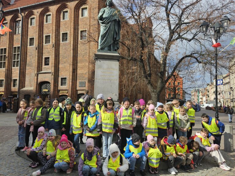 Uczestnicy wycieczki przed pomnikiem Kopernika